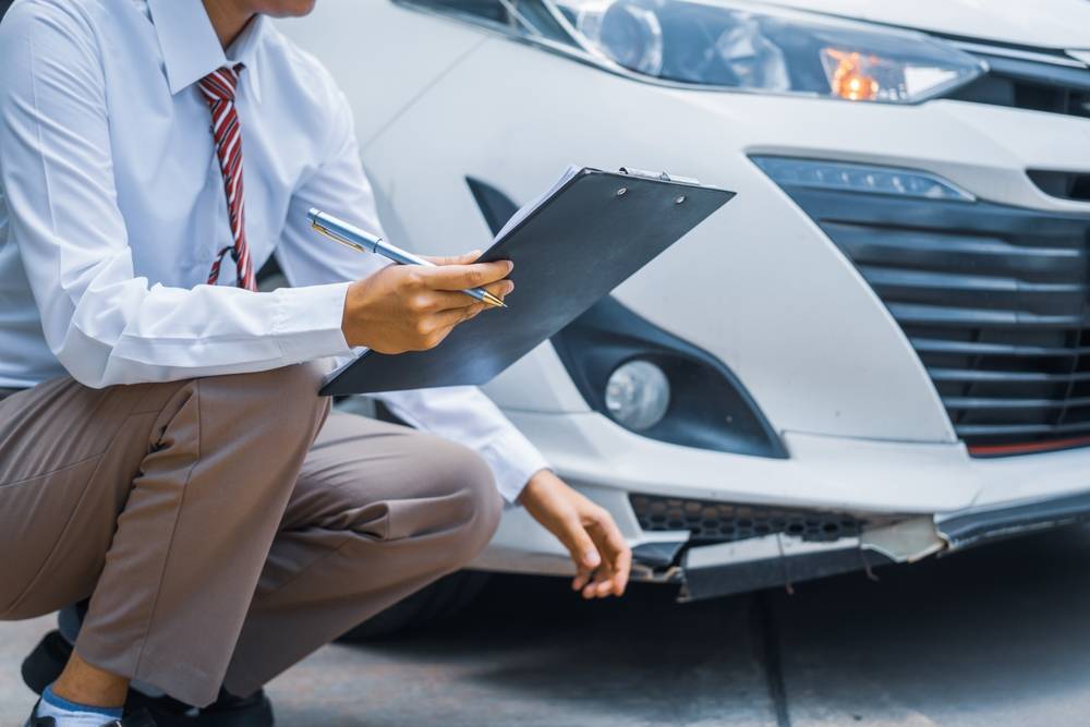 Photo of man next to the damaged car