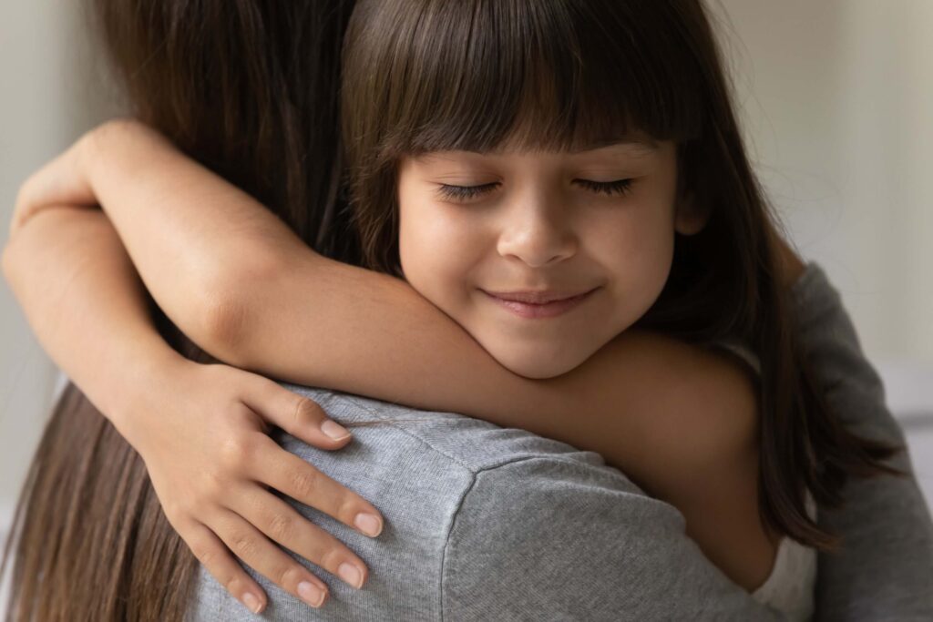 Little daughter with closed eyes cuddling her mother