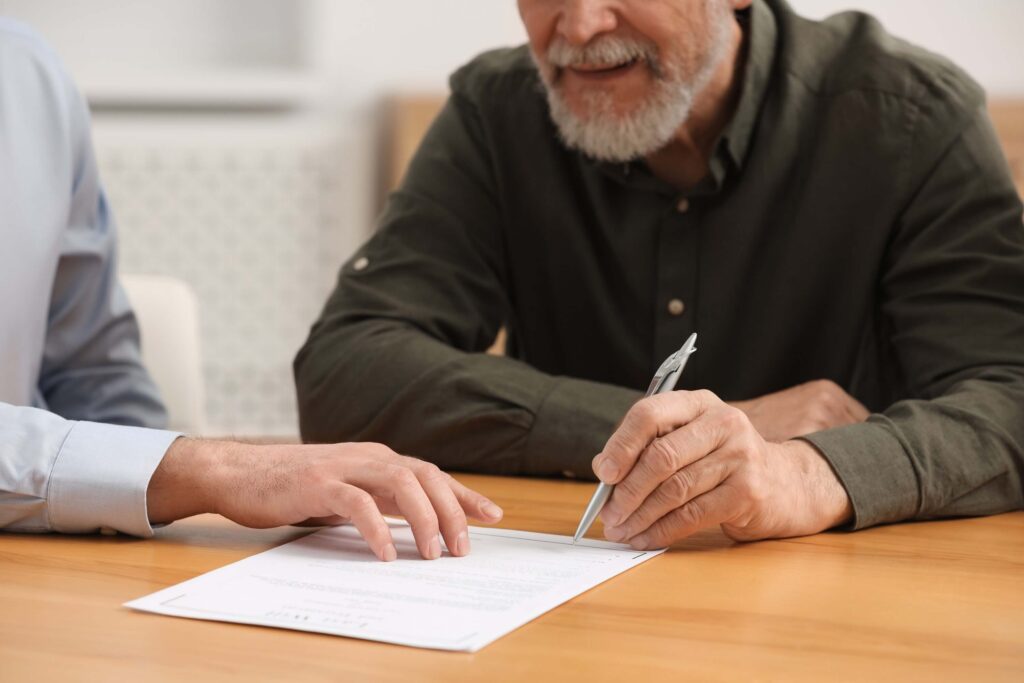 Notary showing senior man where to sign