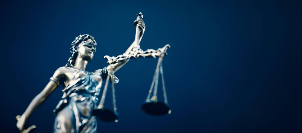 Statue of Lady Justice on blue background